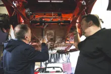 People from independent garage working under car